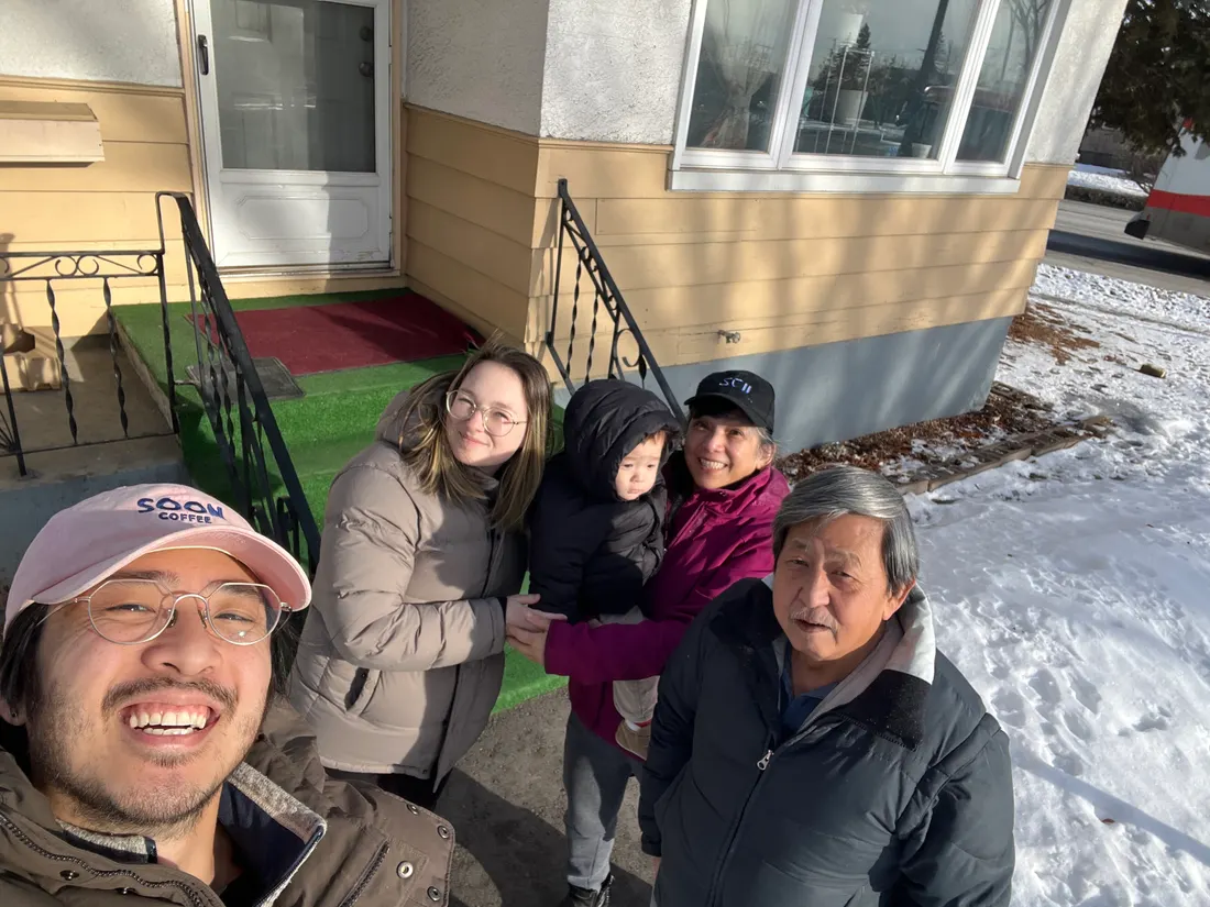 Family selfie in the snow in Calgary with Amadeus at 14 months bundled up in the middle