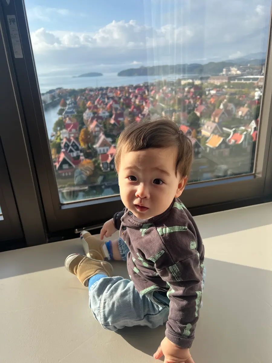 Amadeus at 13 months by a big window overlooking the Dutch-style town of Huis Ten Bosch, Japan